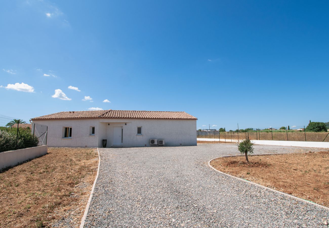 Gravel driveway leading to the entrance of a modern holiday home in Provence under a blue sky