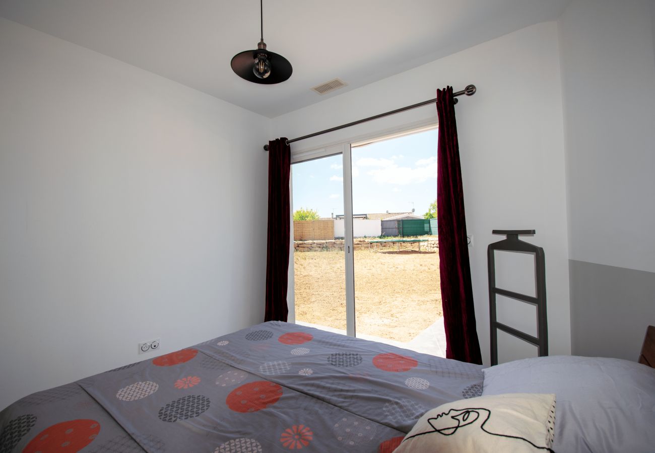 Bedroom with double bed and large window opening to garden.