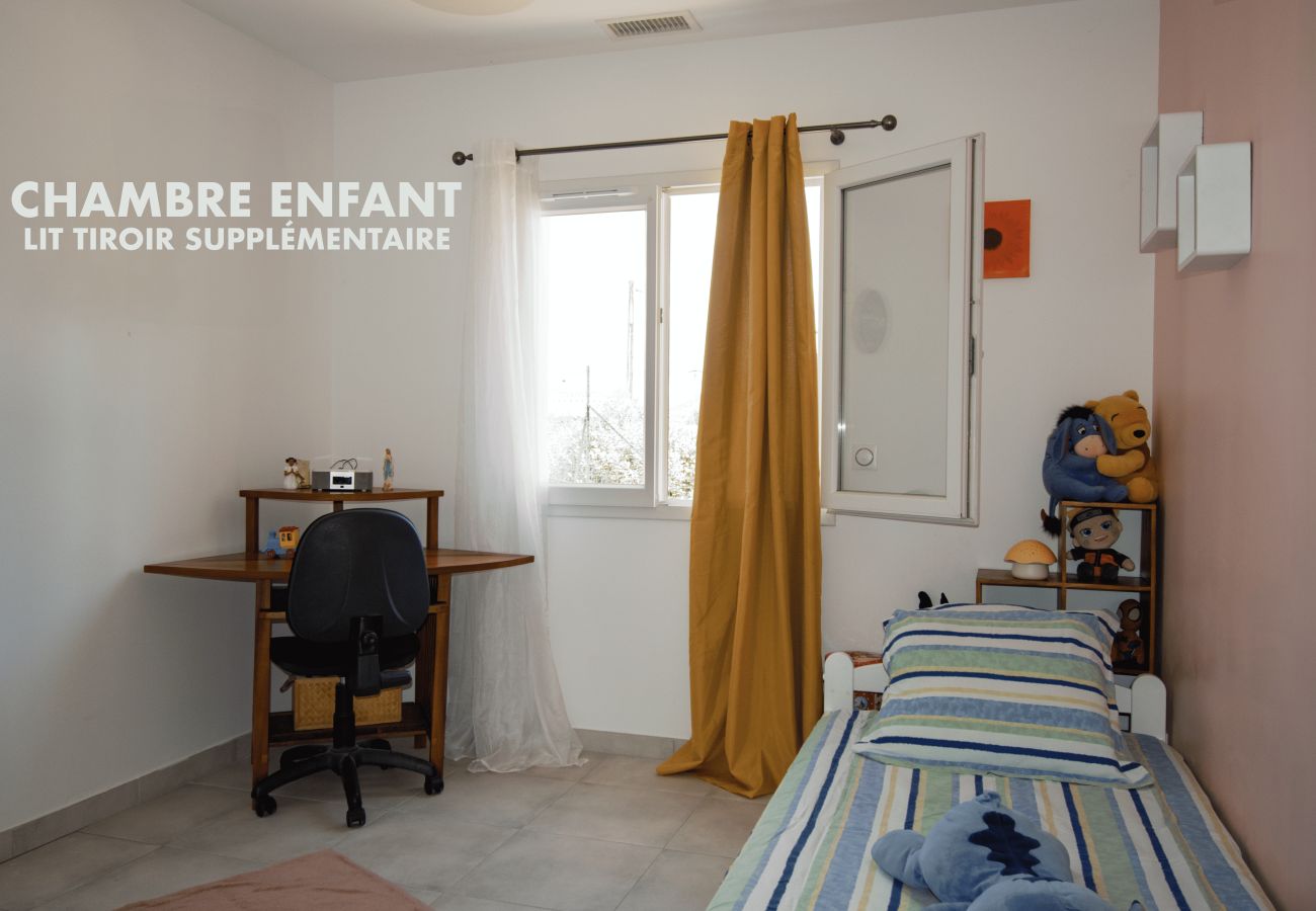 Children’s room with trundle bed and study desk area.