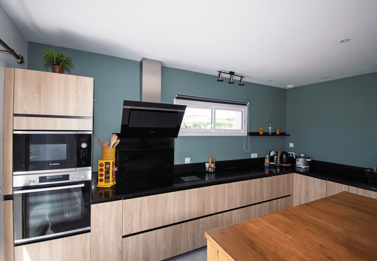 Modern kitchen with built-in appliances and black countertop.