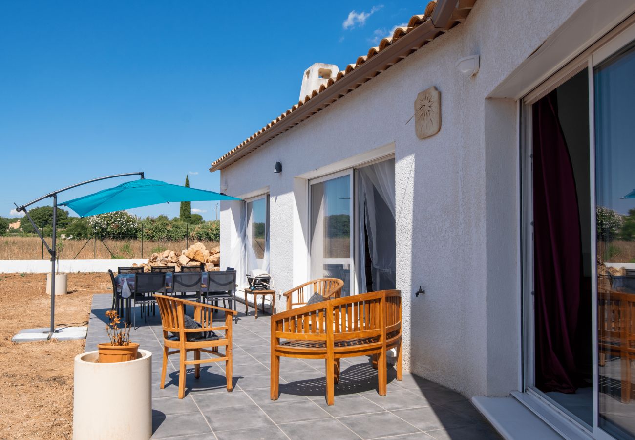 Terrace with wooden chairs and blue parasol.
