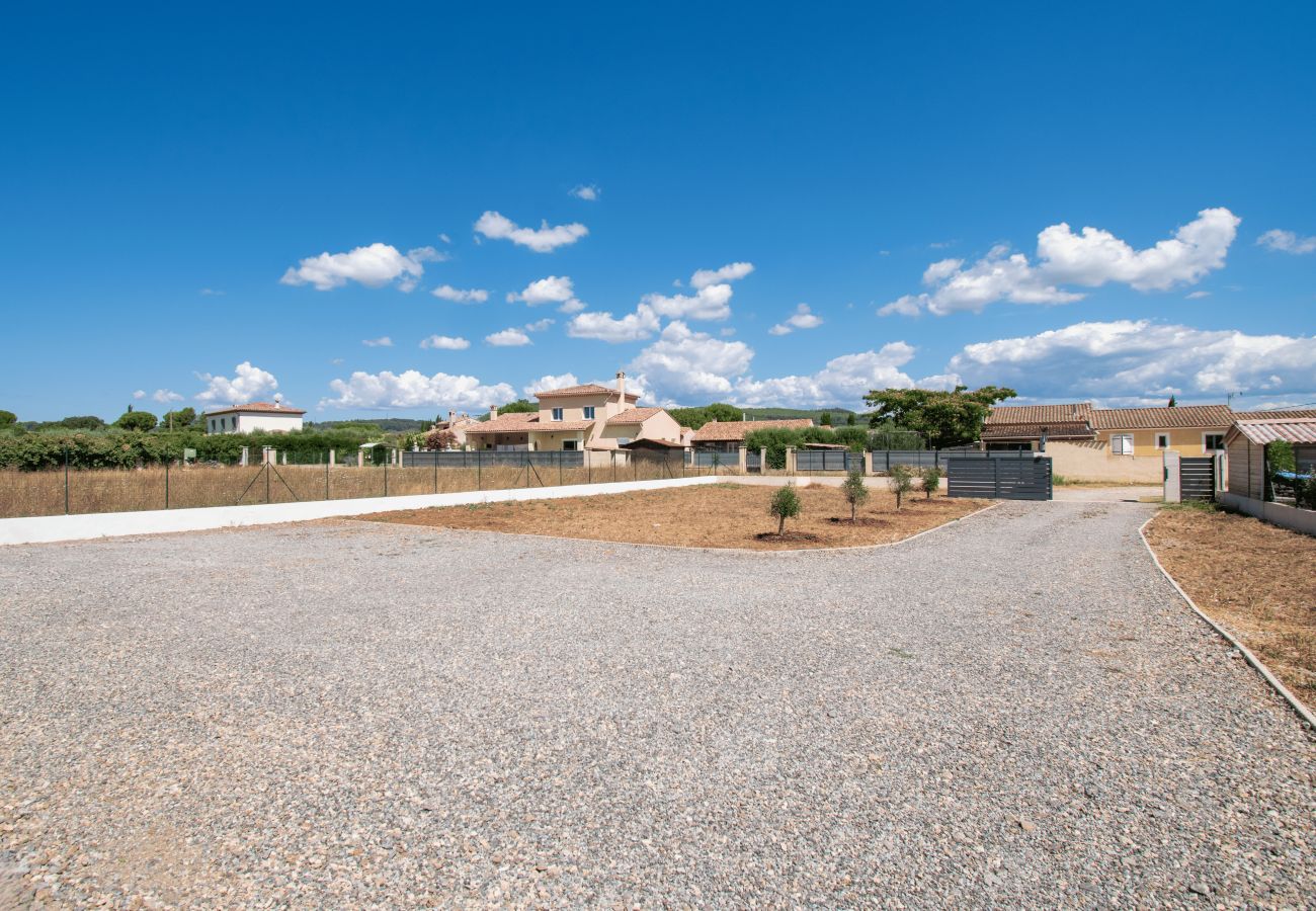 Fenced garden with gravel driveway in front of Provence holiday home.