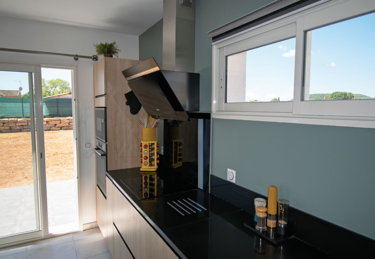 Cocina moderna equipada con encimera negra y gran ventanal.