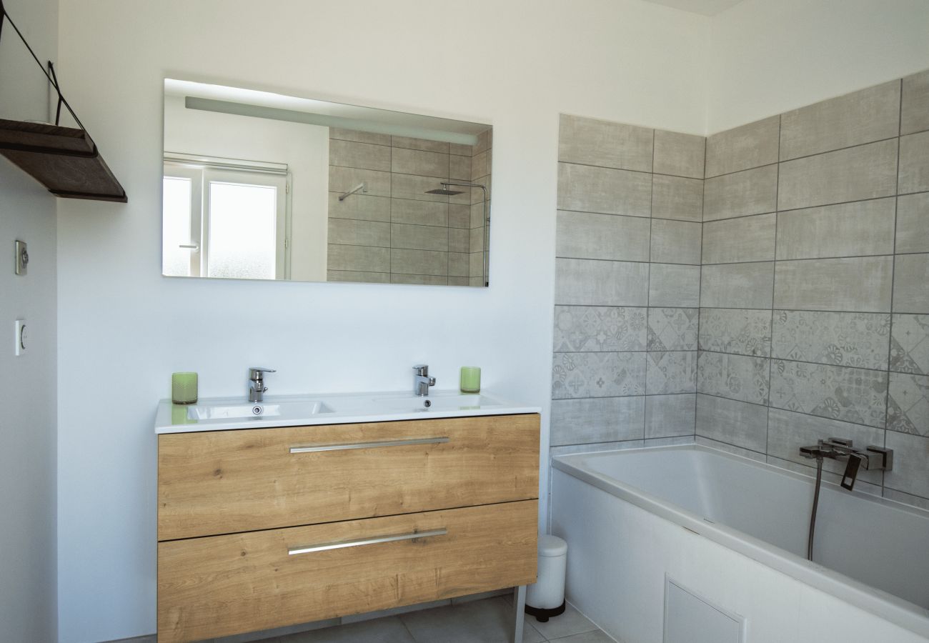 Baño moderno con doble lavabo y bañera alicatada.