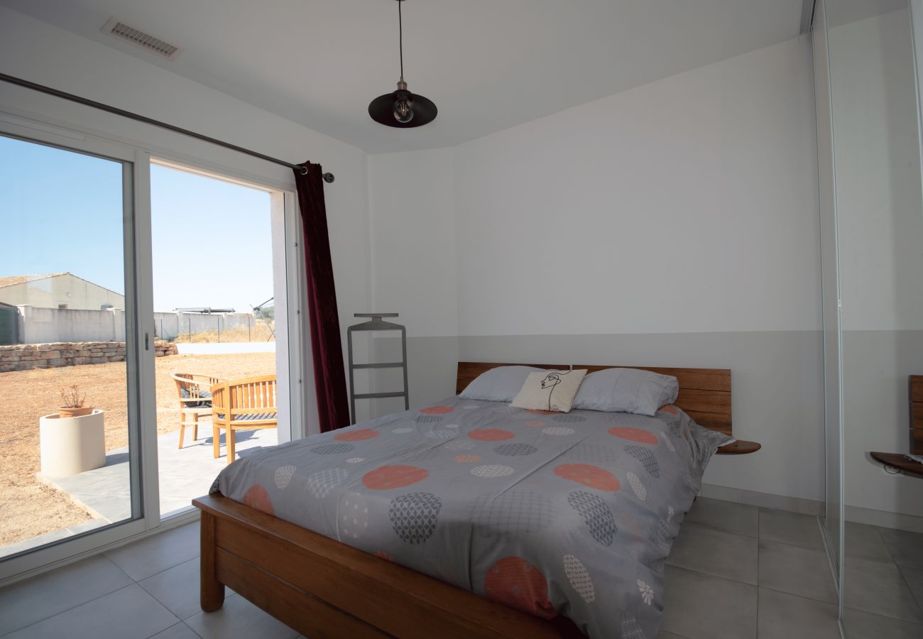 Dormitorio con cama doble y ventanal que da a la terraza.