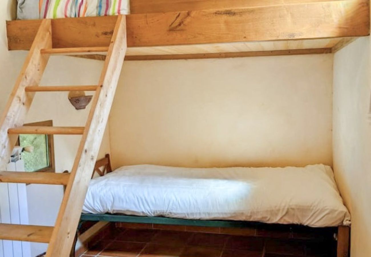 lit mezzanine en bois avec échelle au-dessus d’un lit simple