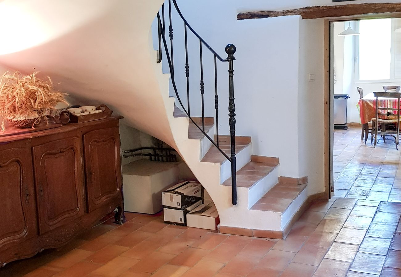 escalier intérieur avec rampe en fer et sol en tomettes anciennes