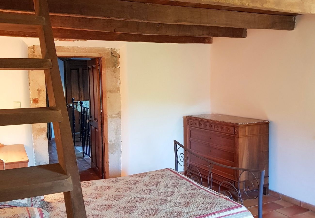 chambre rustique avec poutres bois et escalier vers mezzanine